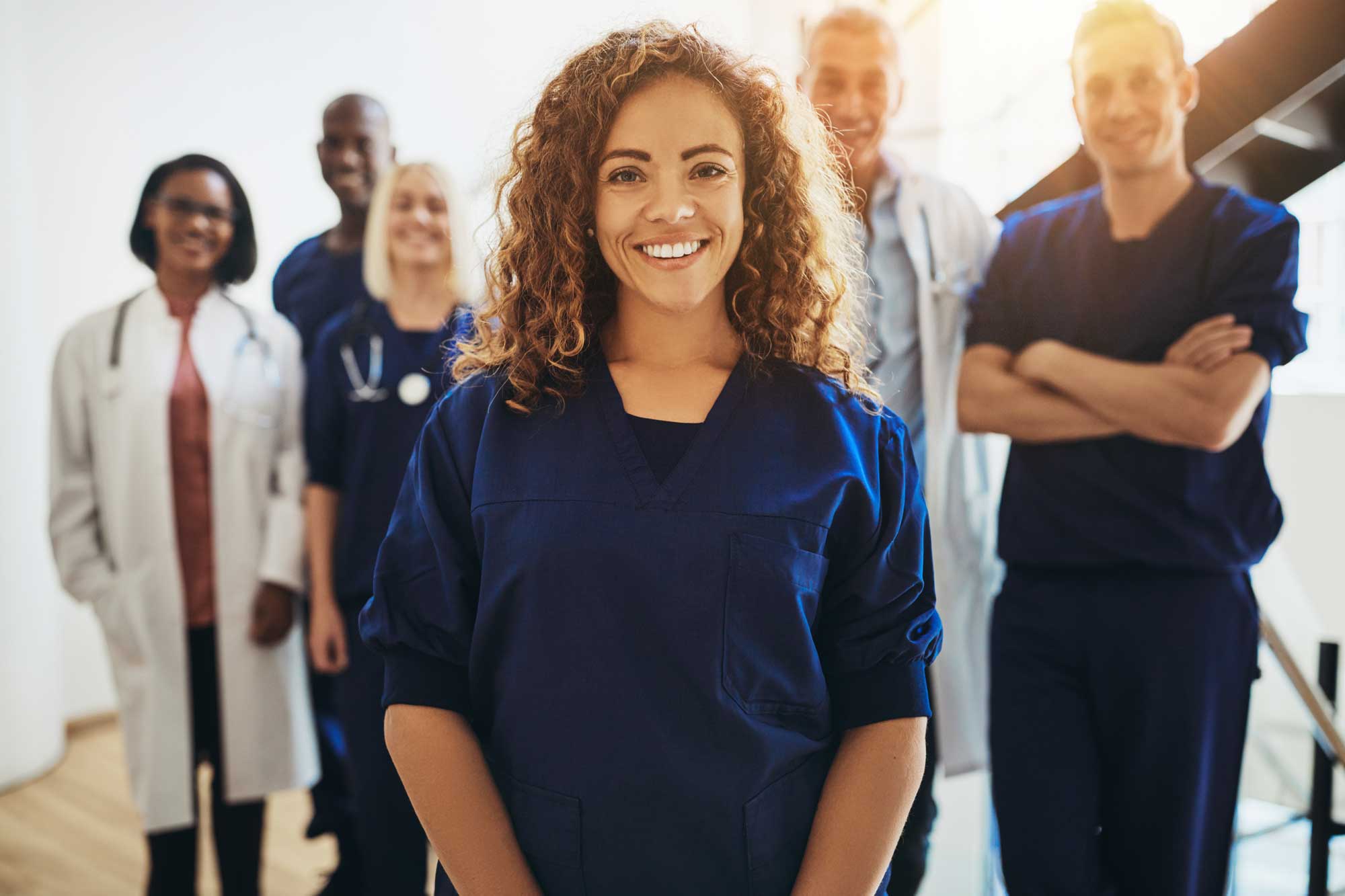 smiling-female-doctor-standing-with-medical-colleagues-in-a-hospital